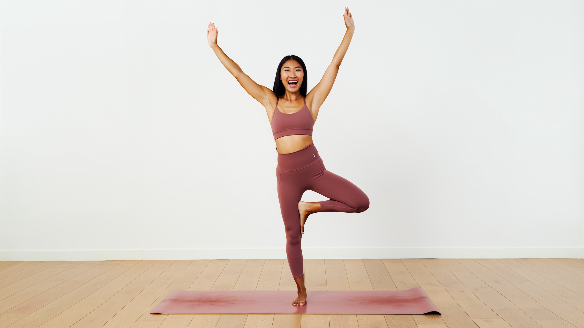 Woman in joyful balance pose on yoga mat